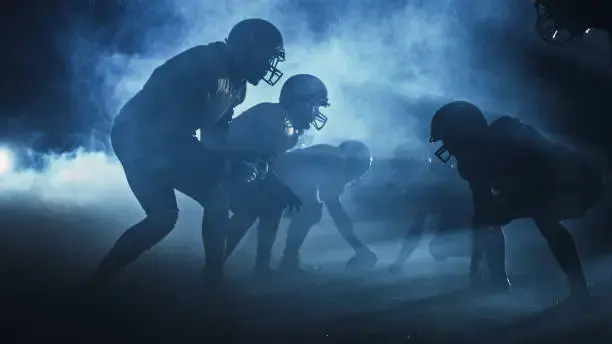 Football players competing on field at night