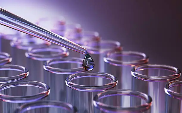 Laboratory pipette dispensing liquid into test tubes